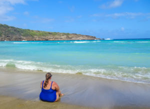 Girl sitting on the beach in Oahu, Hawaii