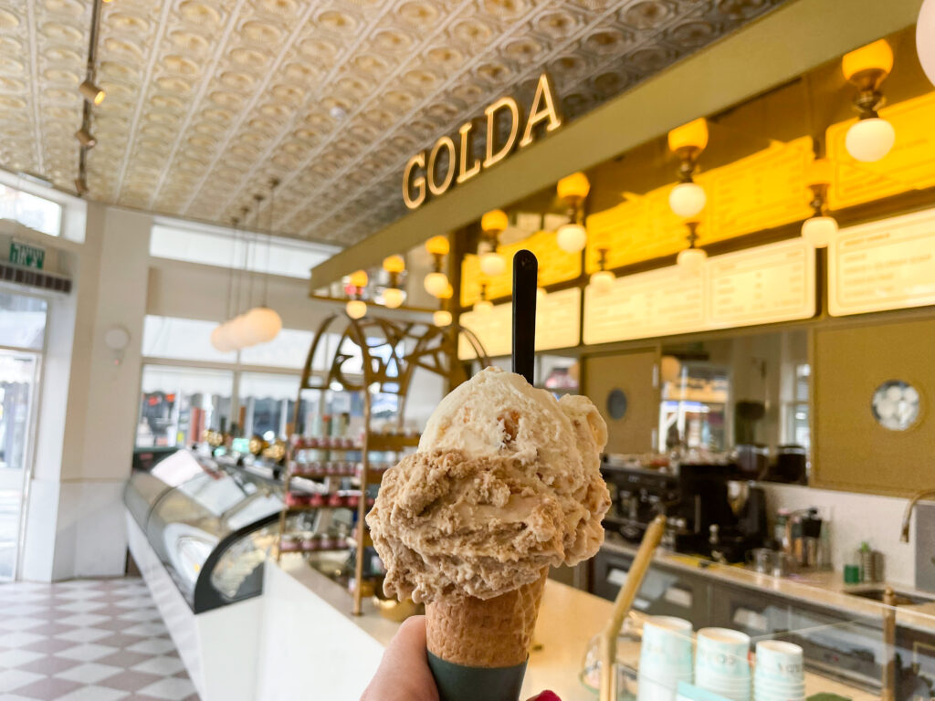 Ice cream cone held up inside Golda ice cream store