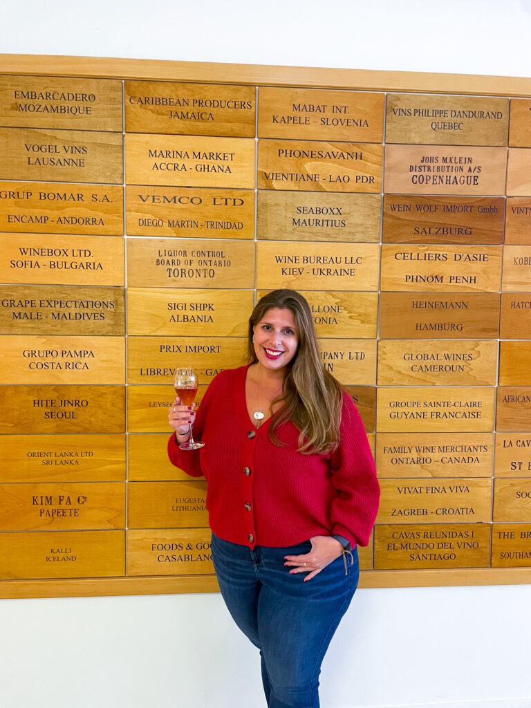 Hannah holding a champagne glass at Tattinger Champagne House