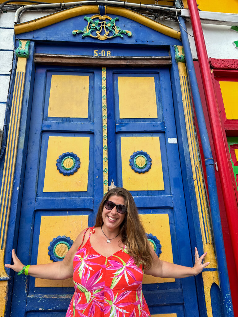 Hannah smiling in front of a blue and yellow door